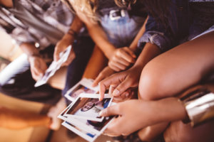 Group of friends looking at ploaroid instant photos in van