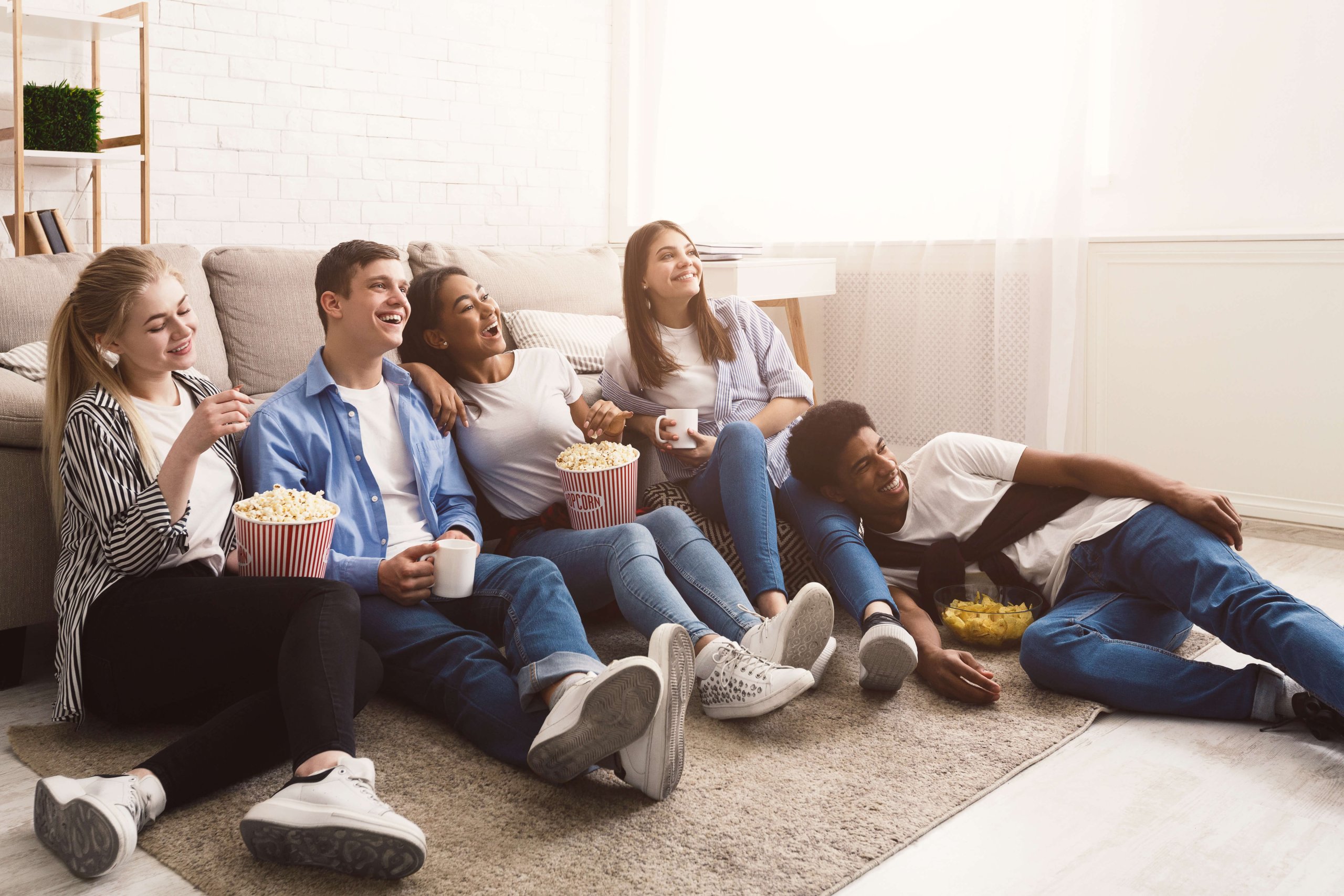 Comedy film. Happy friends watching movie at home
