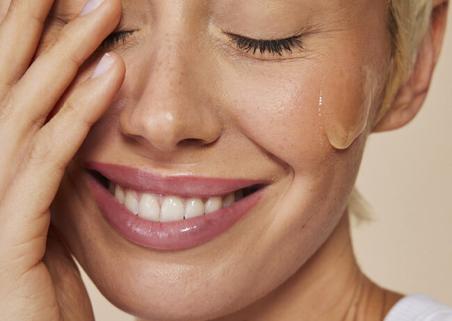Frau mit aufgetragener Gel to Milk Gesichtsmaske von Schaebens auf der Wange.