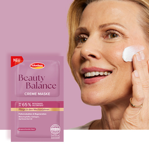 Links die Creme Maske in der Verpackung. Auf der rechten Seite ist die vordere bis linke Hälfte eines Gesichtes einer Frau abgebildet. Auf der oberen Wangenhälfte ist die Creme Maske dekorativ aufgetragen.