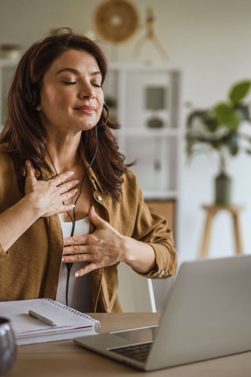 Woman wearing headset meditating during mindful deep breathing exercise
